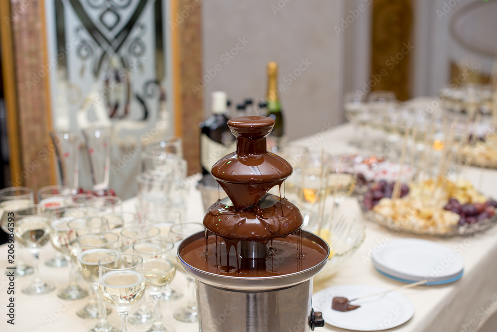 Chocolate Fountain And Fruits For Dessert At Wedding Table