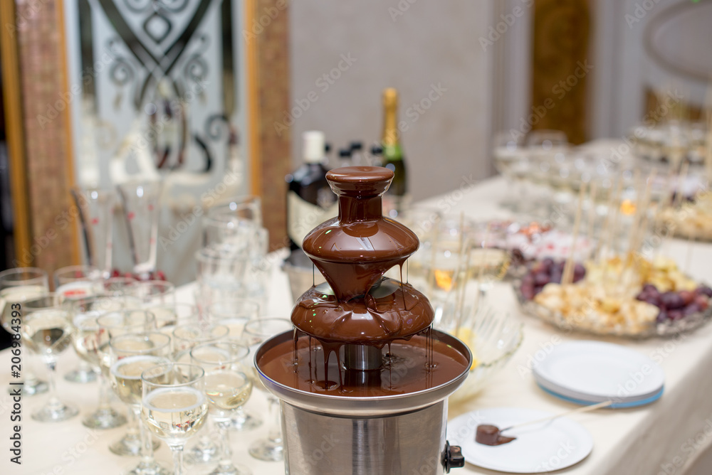 Chocolate Fountain And Fruits For Dessert At Wedding Table Chocolate Fountain And Fruits For Dessert At Wedding Table