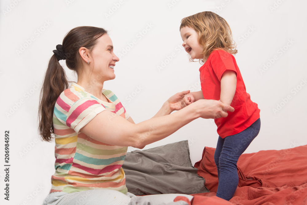 mother with her child girl relaxing and playing in the bed at the weekend together, lazy morning. mother with her child girl relaxing and playing in the bed at the weekend together, lazy morning.