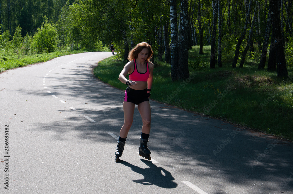Roller skating woman in park rollerblading on inline skates. Beautiful  woman learns to roller skate in the park. Rear view, front view, side view  Stock Photo | Adobe Stock