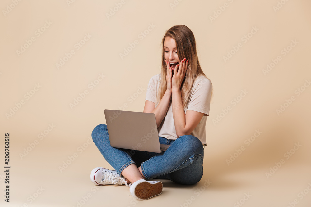 Portrait of an excited casual girl looking at laptop computer Portrait of an excited casual girl looking at laptop computer