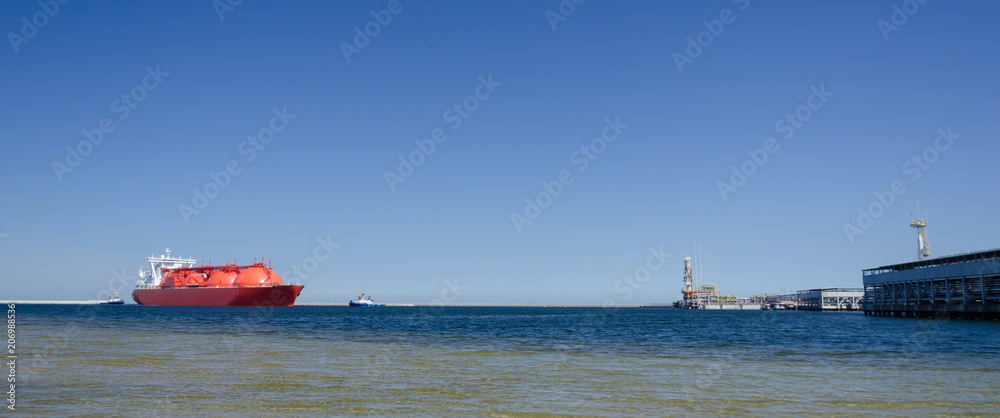 LNG TANKER - The red ship enters port with assurance of tugs

