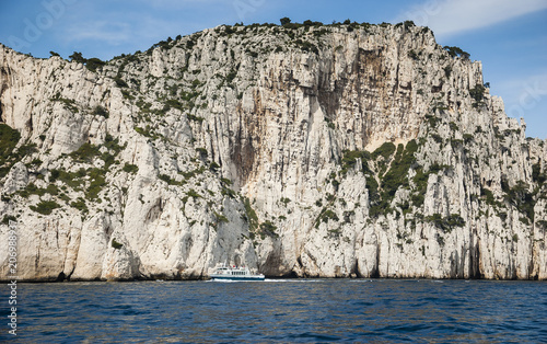 The famous Calanques national park of Cassis (near Marseilles in Provence, France) - blue water, white rocks and tourist ship.