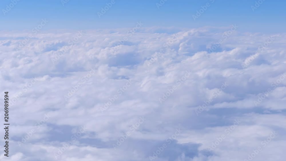 Flying above a thick fluffy cloud cover in the sky Flying above a thick fluffy cloud cover in the sky