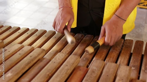 Asian Indonesian Balinese musician gamelan instrument. Closeup hands playing. Not edited, raw file. photo