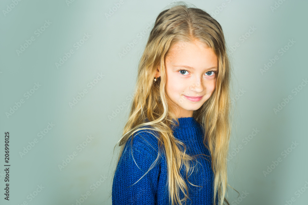 Fototapeta premium Stylish girl with pretty face on grey background. Beauty, kid fashion and healthy hair. Little girl with long hair. Fashion model, beauty, look. Hairdresser, skincare, casual style, denim.