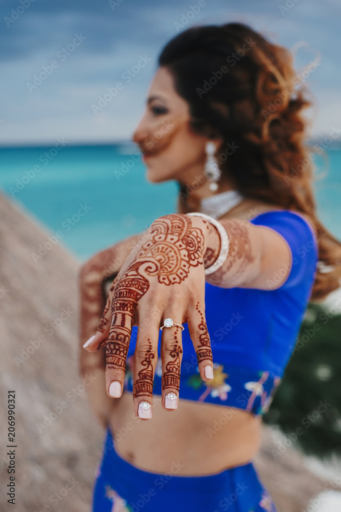 Hindu bride shows her hand covered with henna tattoo and with wedding ring  on a finger Stock Photo | Adobe Stock