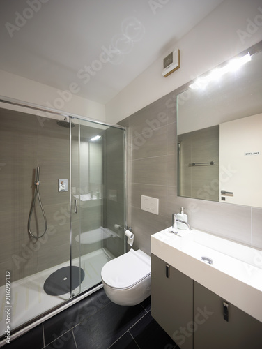 Modern bathroom with large brown tiles and large mirror