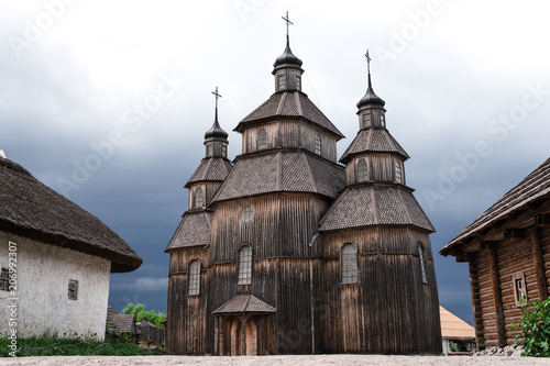 ancient wooden church, of Cossack state guard army troop 16-18 centuries. Khortytsia island on broad Dnipro summertime, wooden church and houses construction technology