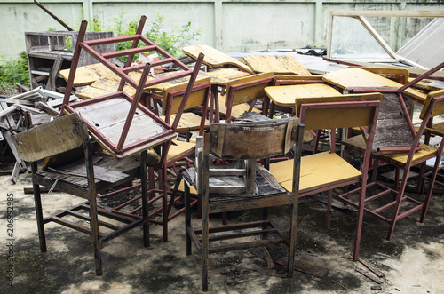 Abandoned broken vintage wooden lecture chairs in old school