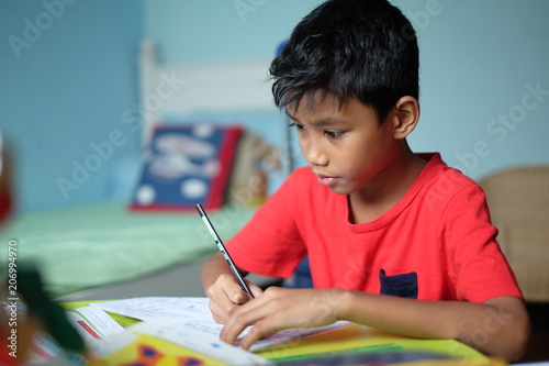 A clever boy doing his homework at hos