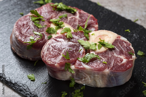 Piece of raw fresh beef shank, lower part of cow's foreleg with fresh green parsley