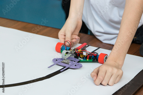 A metal car robot and an electronic board that can be programmed. Robotics and electronics. Laboratory. Mathematics, engineering, science, technology, computer code. STEM education. 