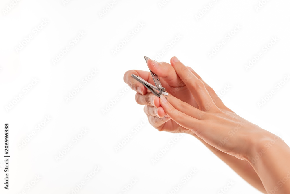 woman hand cutting nails using nail clipper on white backgrounds woman hand cutting nails using nail clipper on white backgrounds