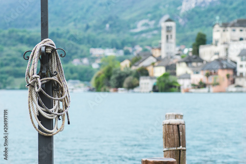 View of the city San Giulio pier  and the island of San Giulio, Lake Orta,Piedmont , Italy. Selective focus, horizontal format © uliab