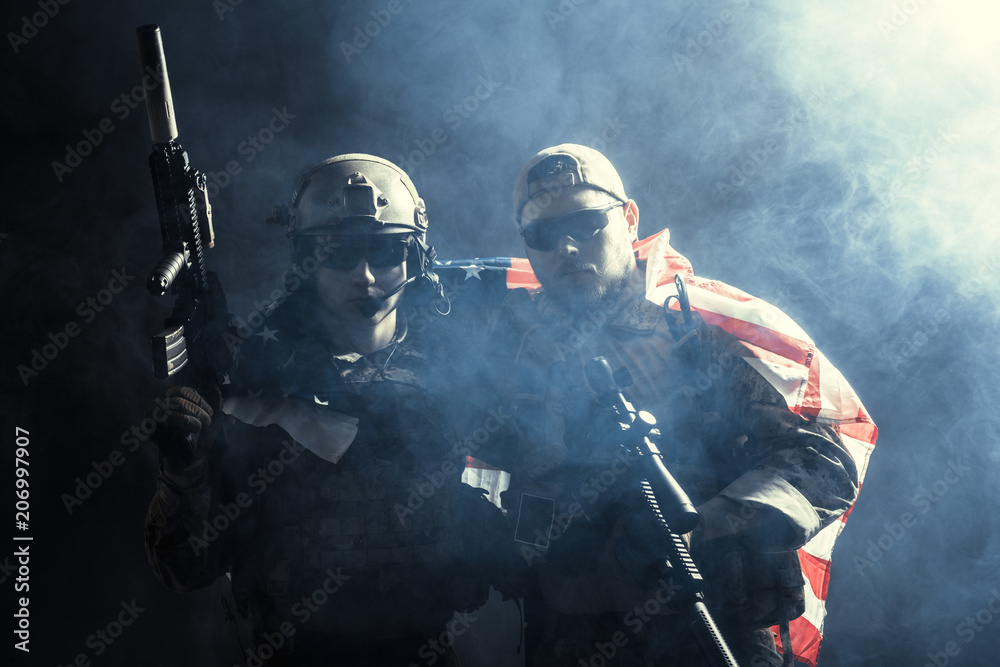 Fototapeta premium Soldier holding machine gun with national flag