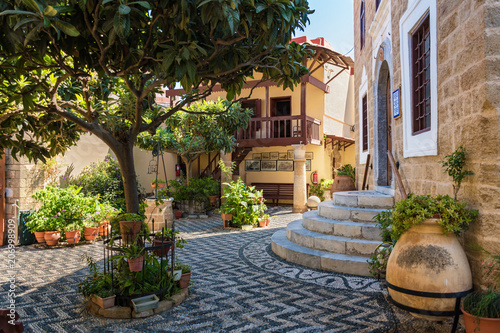Green garden with traditional old houses in old town in City of Rhodes (Rhodes, Greece)