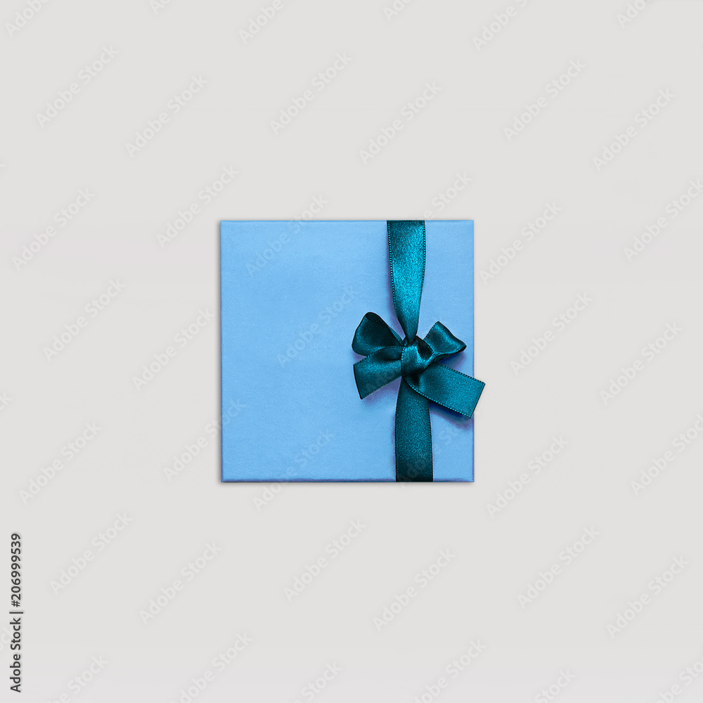 Gift box Minimalist style One blue gift box is lying on light background Photo mock up in top view with copy space Gift box Minimalist style One blue gift box is lying on light background Photo mock up in top view with copy space