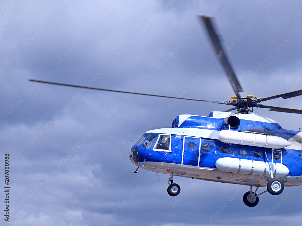 Fototapeta premium White blue helicopter on the sky background.