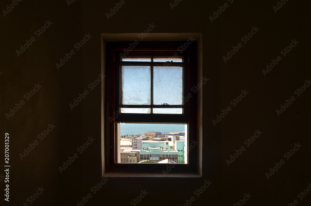 View through window in dark room on city, port elizabeth, south africa View through window in dark room on city, port elizabeth, south africa
