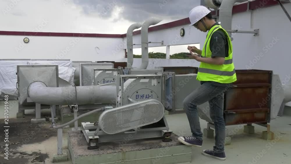 Asian engineer wear safety helmet working on the terrace of the building,Maintenance of air conditioning system in the building,Thailand people Asian engineer wear safety helmet working on the terrace of the building,Maintenance of air conditioning system in the building,Thailand people