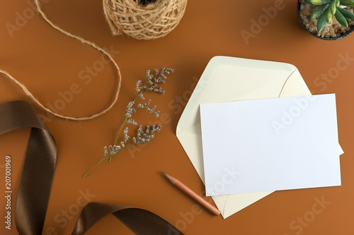 Wedding composition. Wedding Invitation, envelopes, cards Papers on brown background with ribbon and decoration. Top view, flat lay, copy space