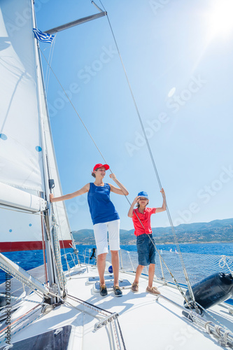 Boy with his sister on board of sailing yacht on summer cruise. Travel adventure, yachting with child on family vacation.