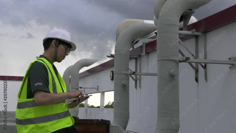 Asian engineer wear safety helmet working on the terrace of the building,Maintenance of air conditioning system in the building,Thailand people Asian engineer wear safety helmet working on the terrace of the building,Maintenance of air conditioning system in the building,Thailand people