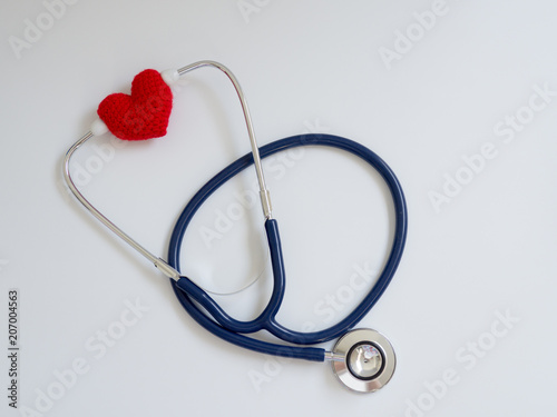 red heart using deep blue stethoscope on the white background. Concept of love and caring patient by the heart. Copy space for the text and contents