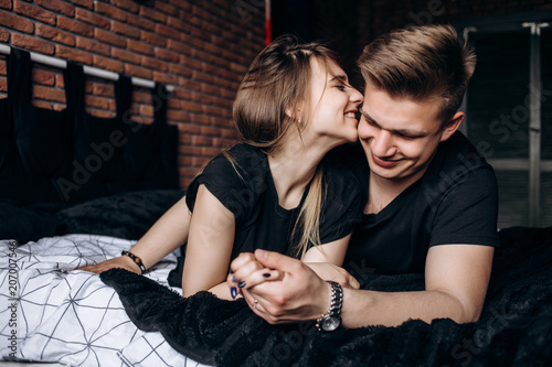 The lovely couple in love embracing and liing  on the bed photo