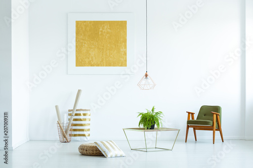 Yellow painting and grey wooden armchair in white living room interior with plant on table. Real photo