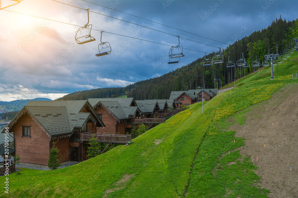 Bukovel, a mountain resort, cottages and a ski lift on a cloudy day.