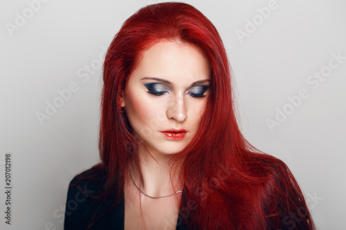 Closeup portrait headshot of beautiful sexy young redhead Caucasian woman with green eyes. Middle age female with long ginger hair. Studio beauty shot.