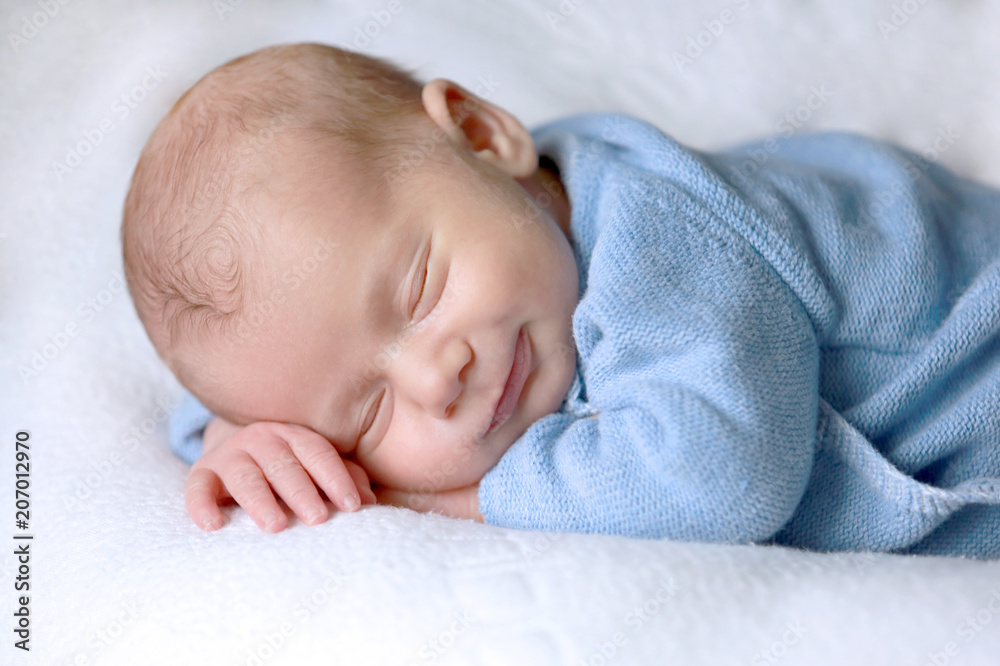 Bébé nouveau-né dort paisiblement avec un sourire Bébé nouveau-né dort paisiblement avec un sourire