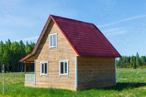 Дом построенный из дерева стоит на зелёном лугу на фоне природы photo