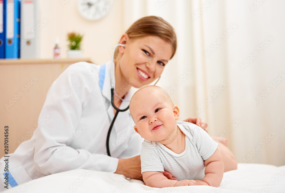 Smiling baby girl in medical office. Young pediatrician examining little child. Smiling baby girl in medical office. Young pediatrician examining little child.