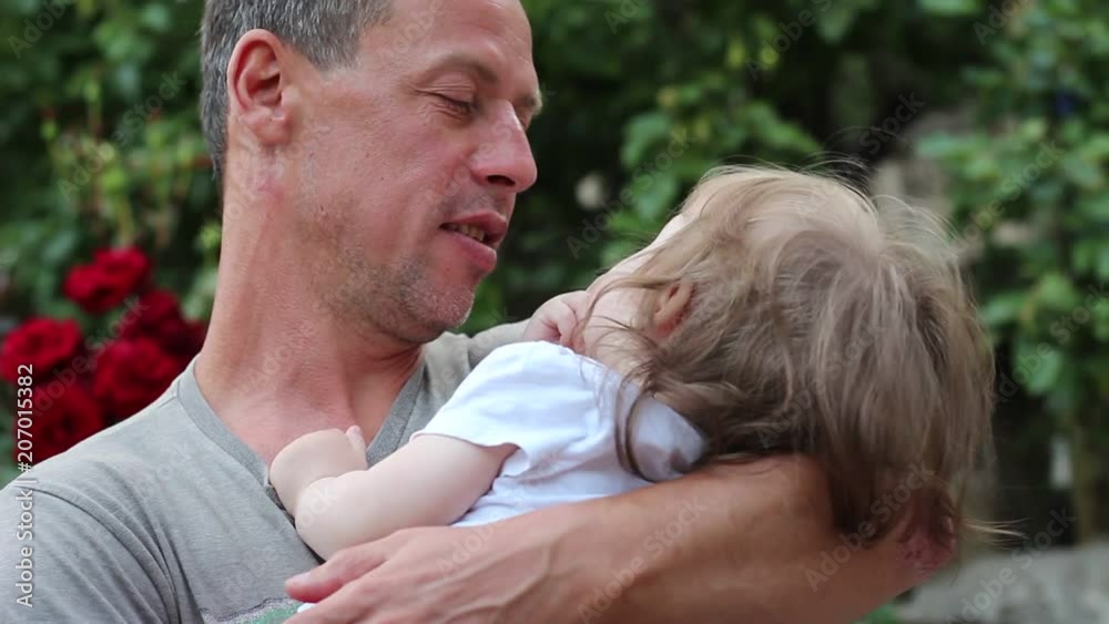 Father lulls child. 40+ year old man and baby. Adult male with gray hair Father lulls child. 40+ year old man and baby. Adult male with gray hair