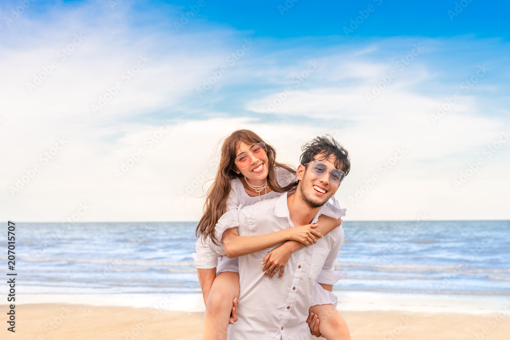 Happy couple in love on beach summer vacations. Joyful girl piggybacking on young boyfriend having fun. Happy couple in love on beach summer vacations. Joyful girl piggybacking on young boyfriend having fun.
