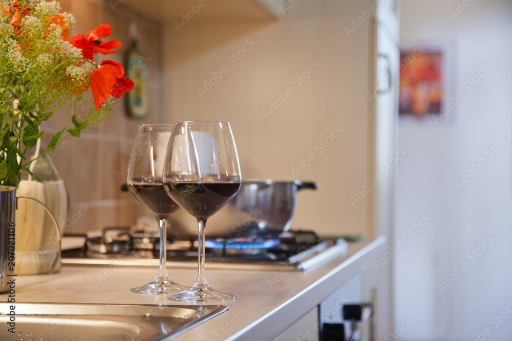 two glasses of red wine on kitchen table two glasses of red wine on kitchen table