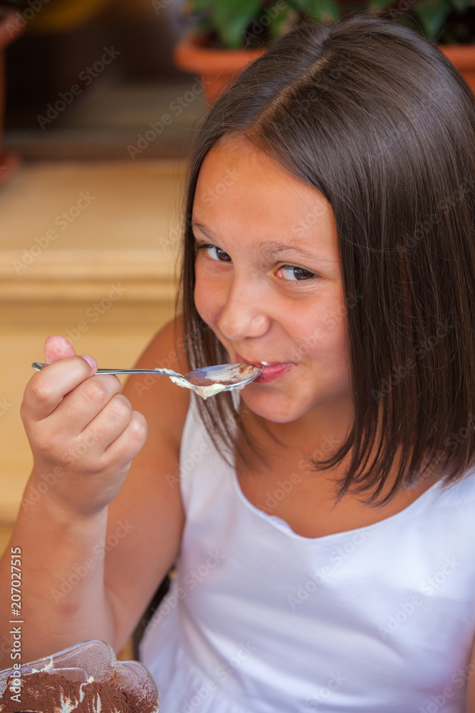 Fototapeta premium girl in a cafe eating an ice cream with a glass