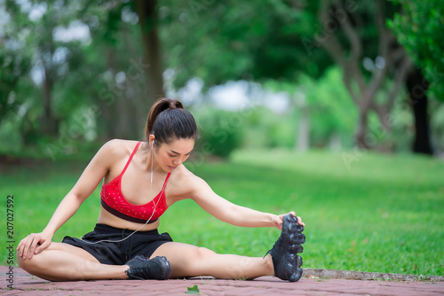 Fototapeta Naklejka Na Ścianę i Meble -  Asian sporty woman stretching body breathing fresh air in the park,Thailand people,Fitness and  exercise concept,Jogging in the park