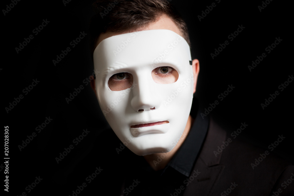 Close-up of a man in a white mask on a black background Close-up of a man in a white mask on a black background