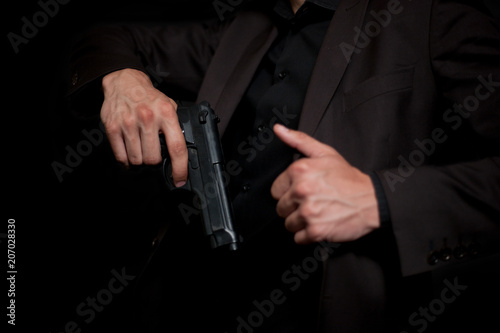 A man pulls a gun from under his jacket