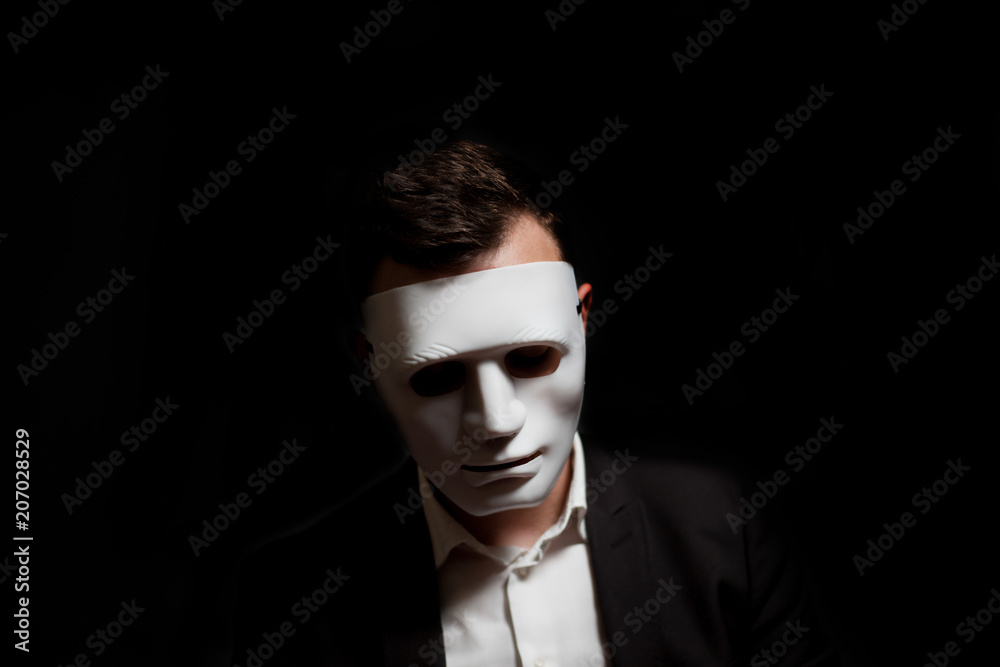 Close-up of a man in a white mask on a black background Close-up of a man in a white mask on a black background