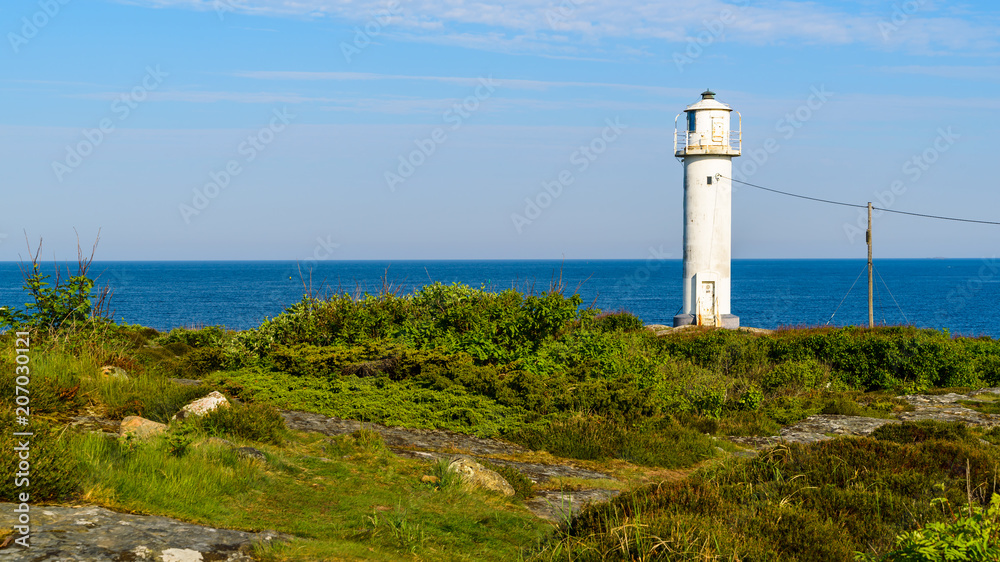 The Subbe lighthouse in southern Varberg, Sweden, with surrounding landscape on a sunny and calm morning.