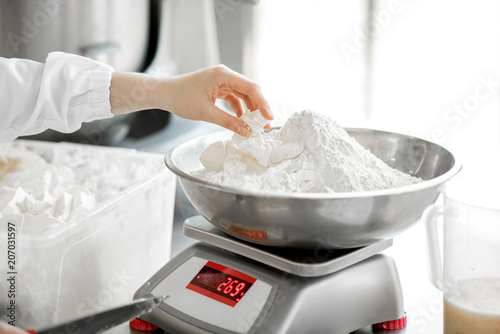 Weighing flour for baking with professional scales at the manufacturing, close-up view