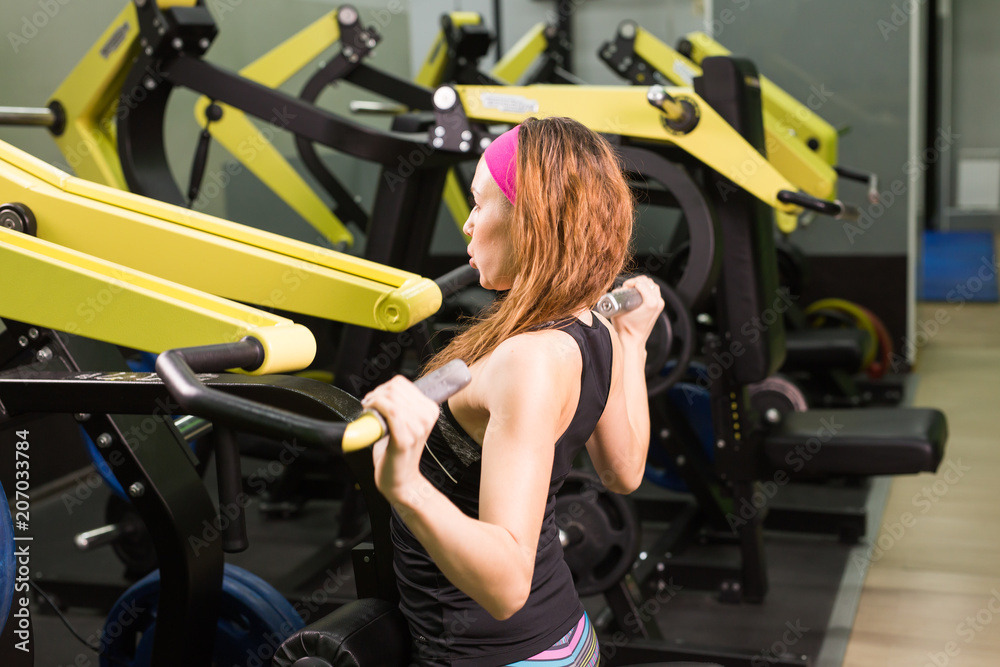 fitness woman execute exercise with exercise machine in gym fitness woman execute exercise with exercise machine in gym