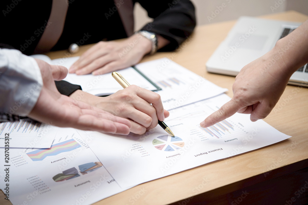 © Chaiphorn - Hands of business people working with papers at meeting together.