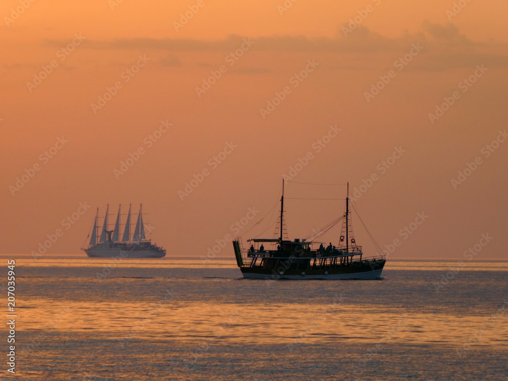 Romantic sunset with a motor and sailing yacht on a warm summer day close to Rovinj, Croatia