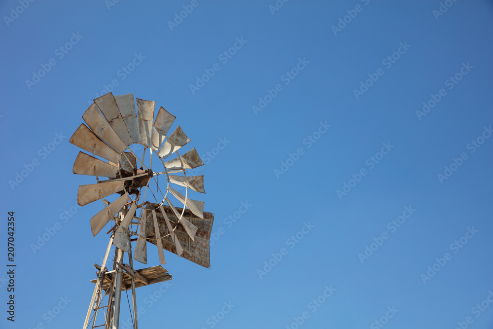 Multi-bladed windpump on blue sky background, copy space Multi-bladed windpump on blue sky background, copy space